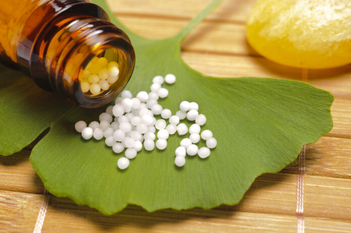alternative Medizin mit homöopathischen Tabletten auf Ginkgoblatt