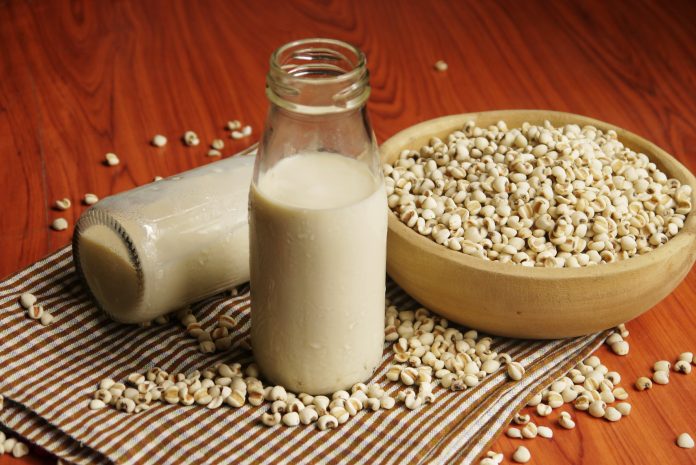 Bottle of soy milk and millet on wooden bowl in the kitchen ,selective focus.