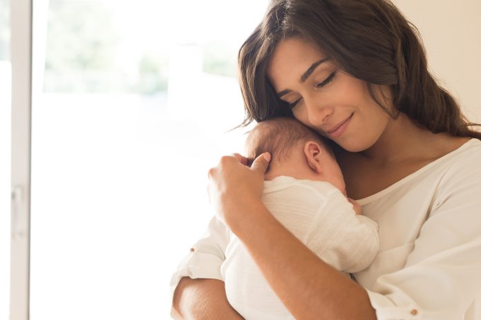 Bonita mujer con un bebé recién nacido en brazos