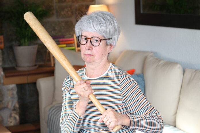 Senior woman holding baseball bat.