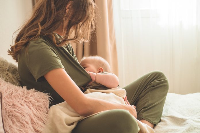 El concepto de la lactancia materna. Retrato de mamá y bebé amamantando.