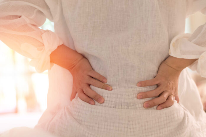 Back pain in woman concept. Female patient hurt from lower backache from bowel and bladder problems, palvic inflammatory disease (PID) or motherhood pregnancy.