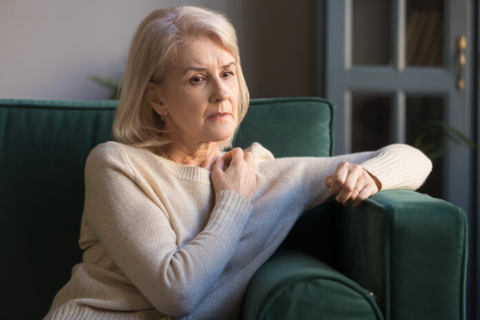Ältere grauhaarige nachdenklich depressive Frau sitzen auf dem Sofa allein zu Hause verloren auf traurige Gedanken, Großmutter Denken über Probleme Schwierigkeiten, mit senilen Krankheiten, geistige emotionale Störungen Konzept