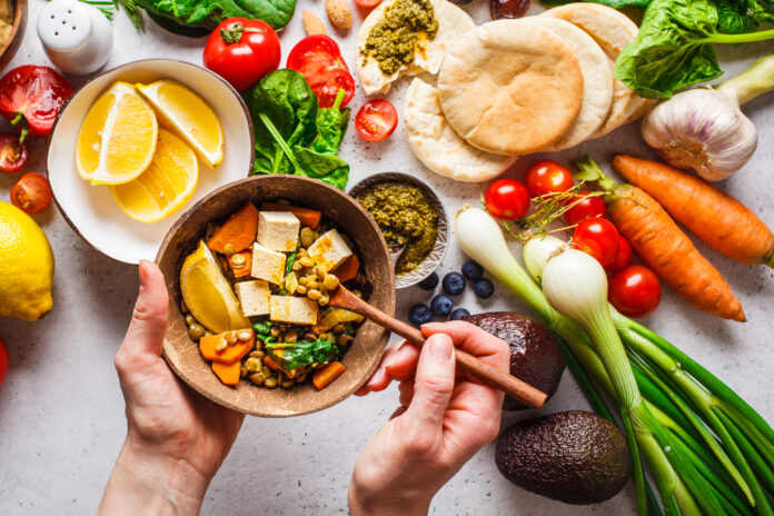 Gesundes vegetarisches Essen Hintergrund. Gemüse, Hummus, Pesto und Linsencurry mit Tofu.