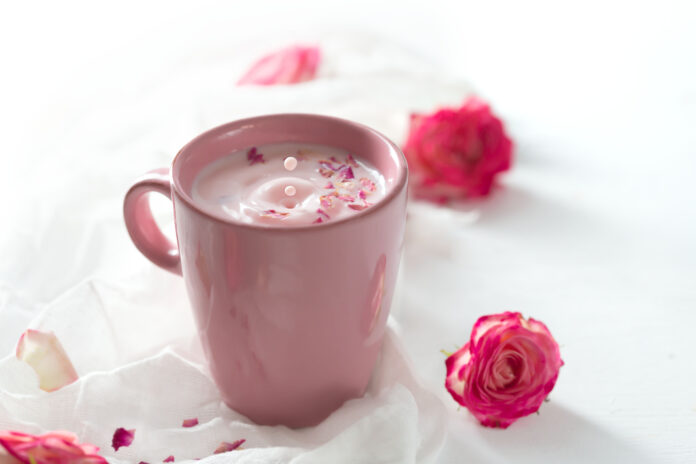 Rose moon milk for a better sleep on a white background. Ayurveda warm drink consumed before bed. Nice in case of sleeplessness, anxiety and insomnia