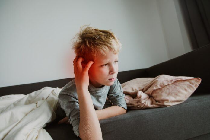 Krankes Kind mit Ohrenschmerzen, scharfem Schmerzkonzept, Virus oder Infektion