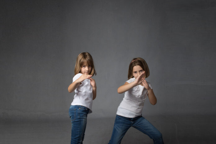 children in a karate defense, dark background