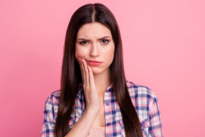 Close-up portrait of her she nice-looking attractive cute charming sad straight-haired lady having pain attack teeth damage care oral hygiene isolated over pink pastel background.