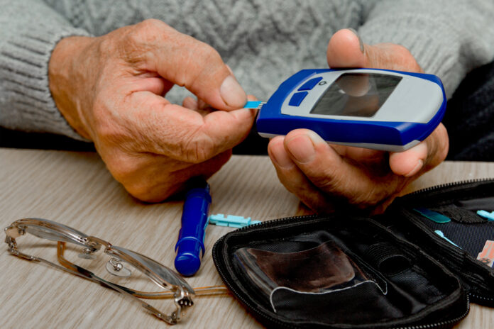Concept diabetes in the elderly retired. Senior man with glucometer checking blood sugar level at home. Learn to use a glucometer