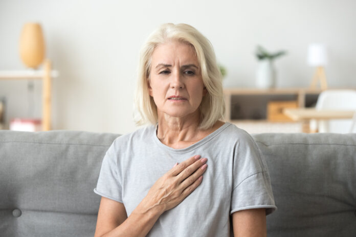 Upset gestresst reifen Frau mittleren Alters Gefühl Schmerzen berühren Brust mit Herzinfarkt, traurig besorgt ältere ältere Dame leidet unter Herzschmerzen zu Hause, Infarkt oder weibliche Herzkrankheit Konzept