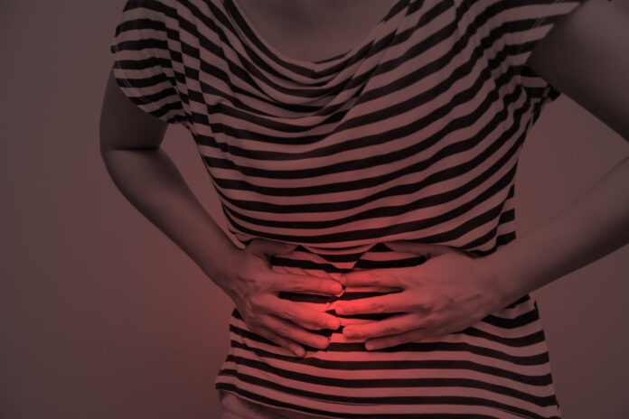 Young woman having abdominal pain, upset stomach or menstrual cramps