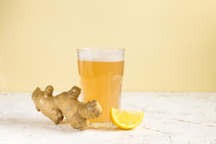 a glass of ginger beer with root and orange
