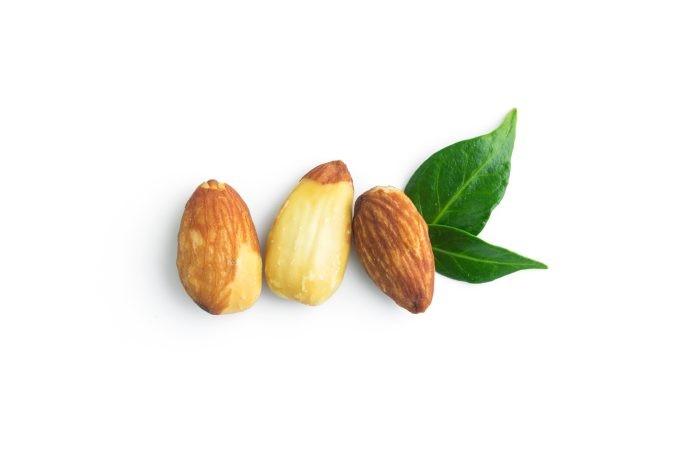 almonds with leaves in top view isolated on white background