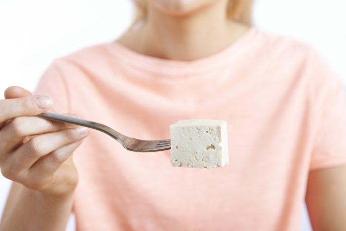Close Up Of Woman With Tofu On Fork