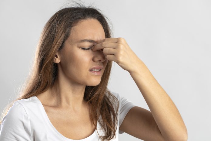 Young woman suffering from symptoms of sinus infection