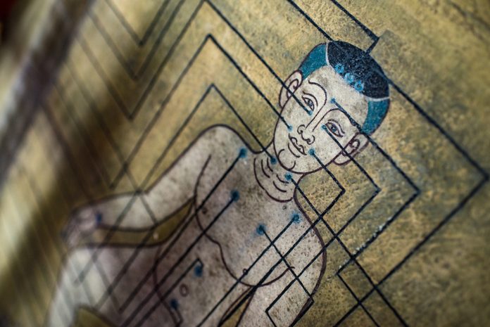 Antigua pintura mural tailandesa que representa un gráfico de los puntos de acupuntura del hombre en ángulo